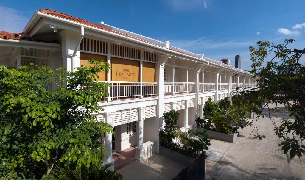 a white building with trees in front of it at 1926 Heritage Hotel Penang by The Unlimited Collection in George Town