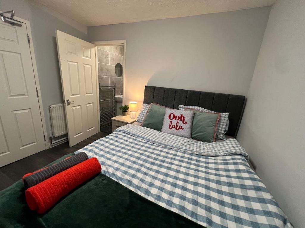 ein Schlafzimmer mit einem Bett mit einem roten Kissen darauf in der Unterkunft Rare 4 en-suite Bedroom Flat with Free Parking and workspace in Warwick