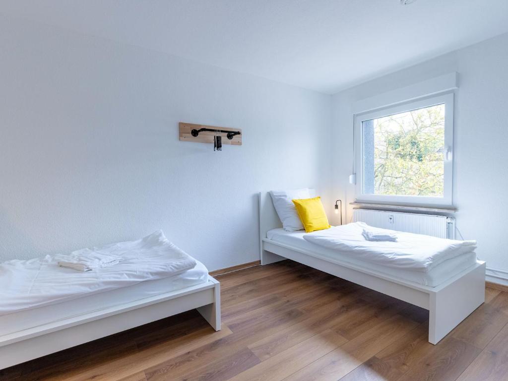 zwei Betten in einem Zimmer mit Fenster in der Unterkunft BudgetRoom 3 Schlafzimmer Workers Home in Marl