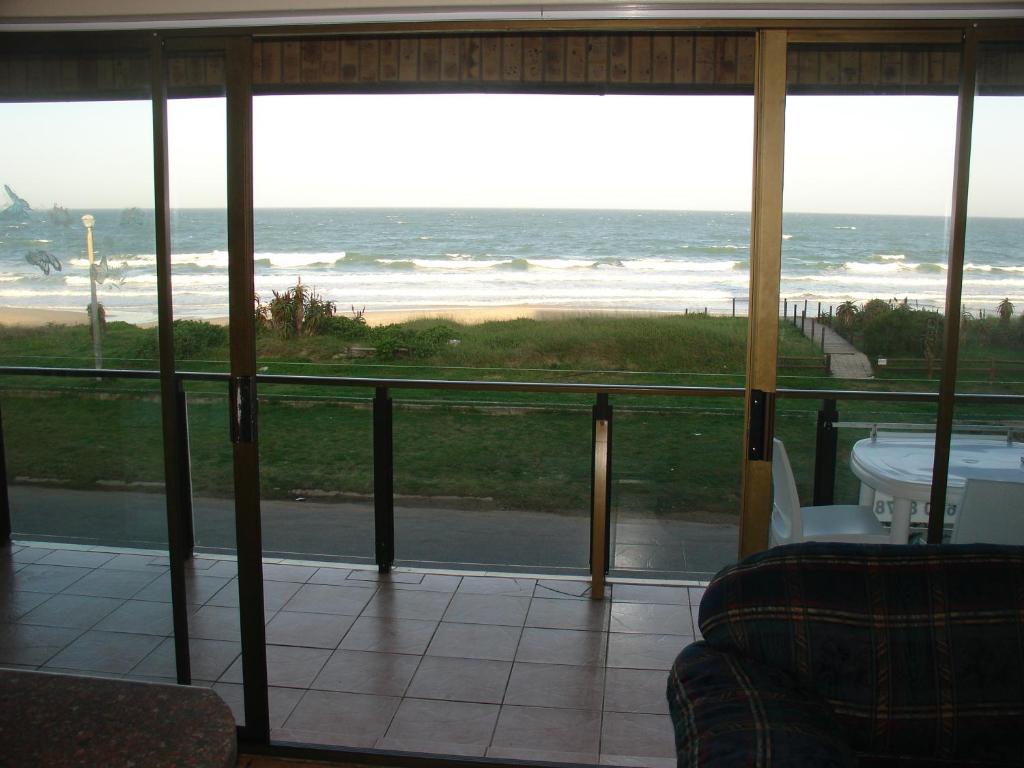 a screened in porch with a view of the ocean at Blue Horizon Flat 8 in Jeffreys Bay