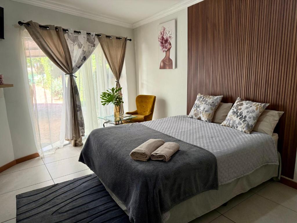 a bedroom with a bed with two towels on it at The Minimalist Suite in Kempton Park