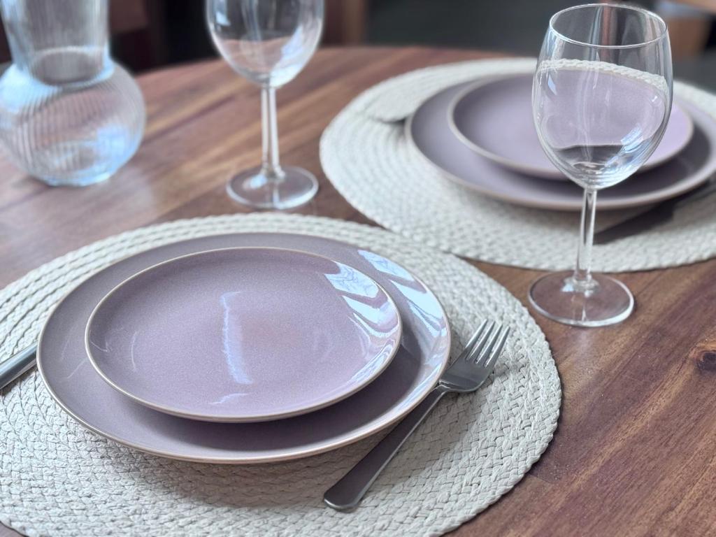 a wooden table with plates and wine glasses on it at Saulgrieži 7 in Ventspils