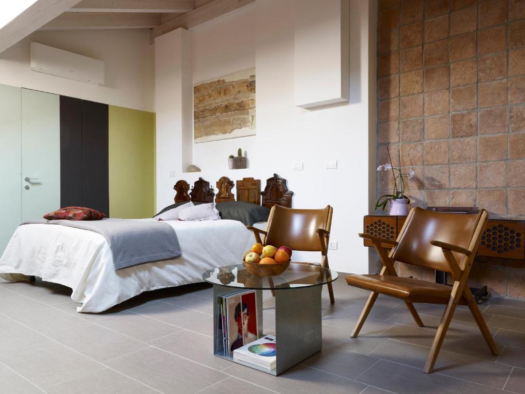 a bedroom with a bed and a table and chairs at B&B Sottotetto in Reggio Emilia