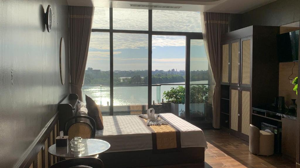 Zimmer mit einem großen Fenster, einem Bett und einem Tisch in der Unterkunft MD Hotel in Mỹ Lộc