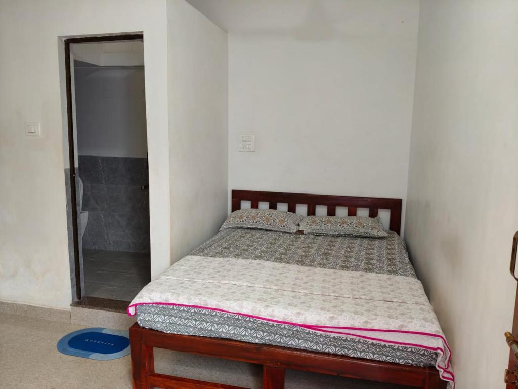 een slaapkamer met een bed met een spiegel en een douche bij Laxmi house in Arambol