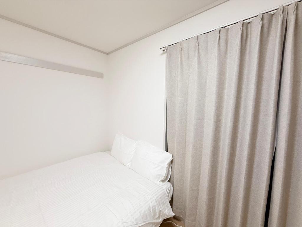 Ένα ή περισσότερα κρεβάτια σε δωμάτιο στο 東三国民泊