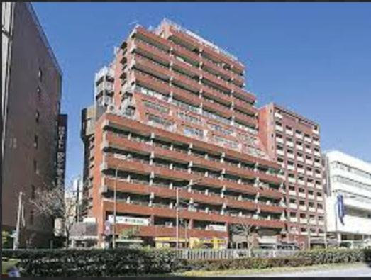 a large brick building in the middle of a city at SJins in Tokyo