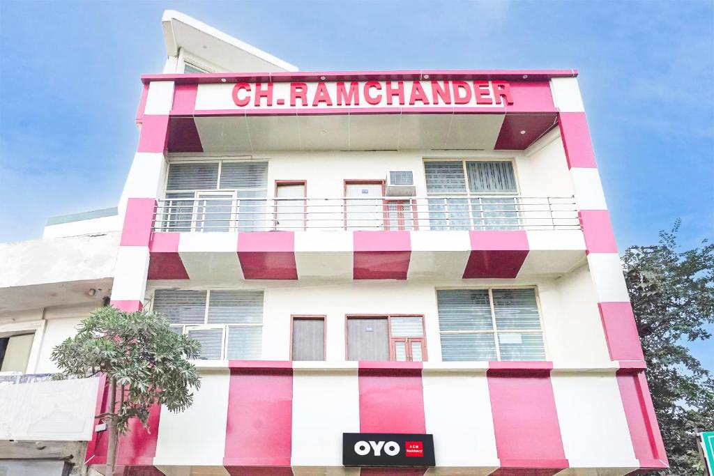 een roze en wit gebouw met een bord erop bij Hotel O Madhur Milap in Sohna