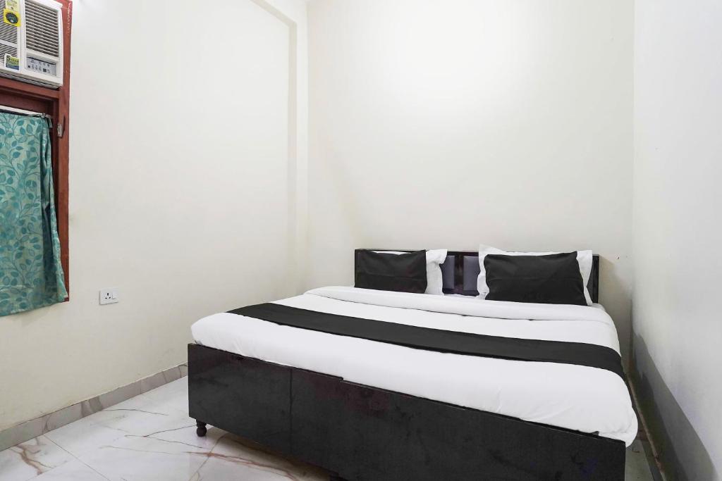 uma cama com travesseiros pretos e brancos em um quarto em Hotel O A G M Residency em Sohna