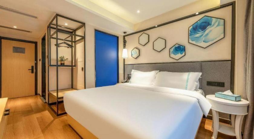 1 dormitorio con 1 cama blanca grande y lavamanos en Xana Lite· Xi'an South Gate Yongningmen Subway Station, en Xi'an