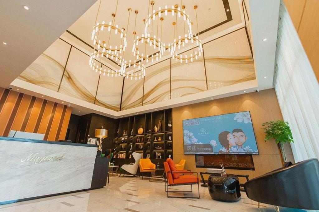 una grande hall con un lampadario e una televisione di Magnotel Tongxiang Shimao Center a Tongxiang