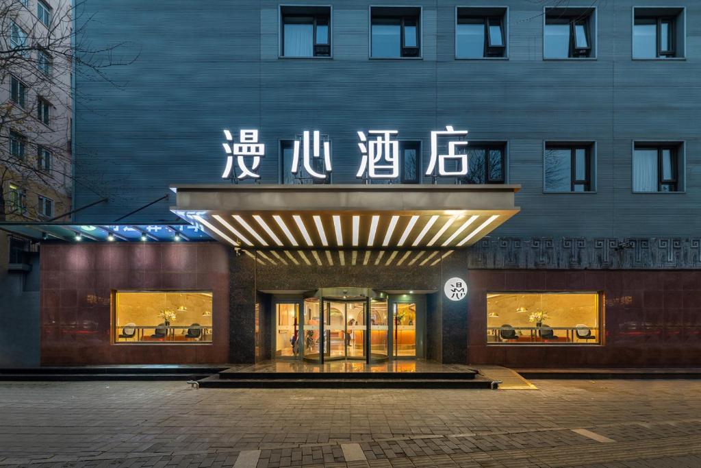 a building with a sign on the front of it at Beijing Tiananmen Square Manxin Hotel in Beijing
