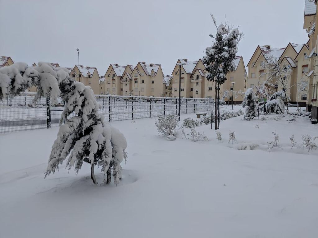 a snow covered yard with houses in the background at Le séjour agréable in Ifrane