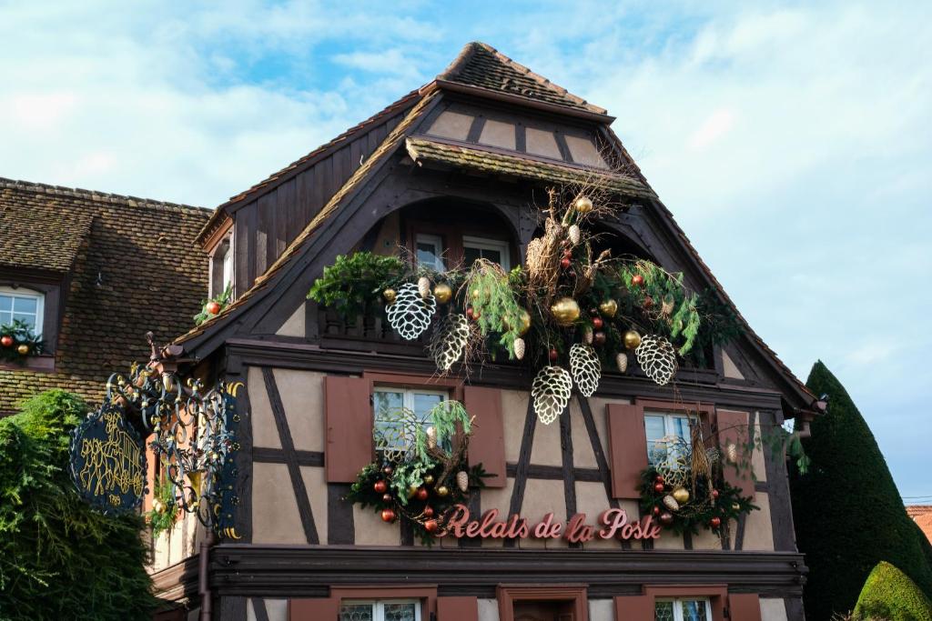 una casa con decorazioni natalizie a lato di Hôtel Restaurant Relais De La Poste - Strasbourg Nord a La Wantzenau