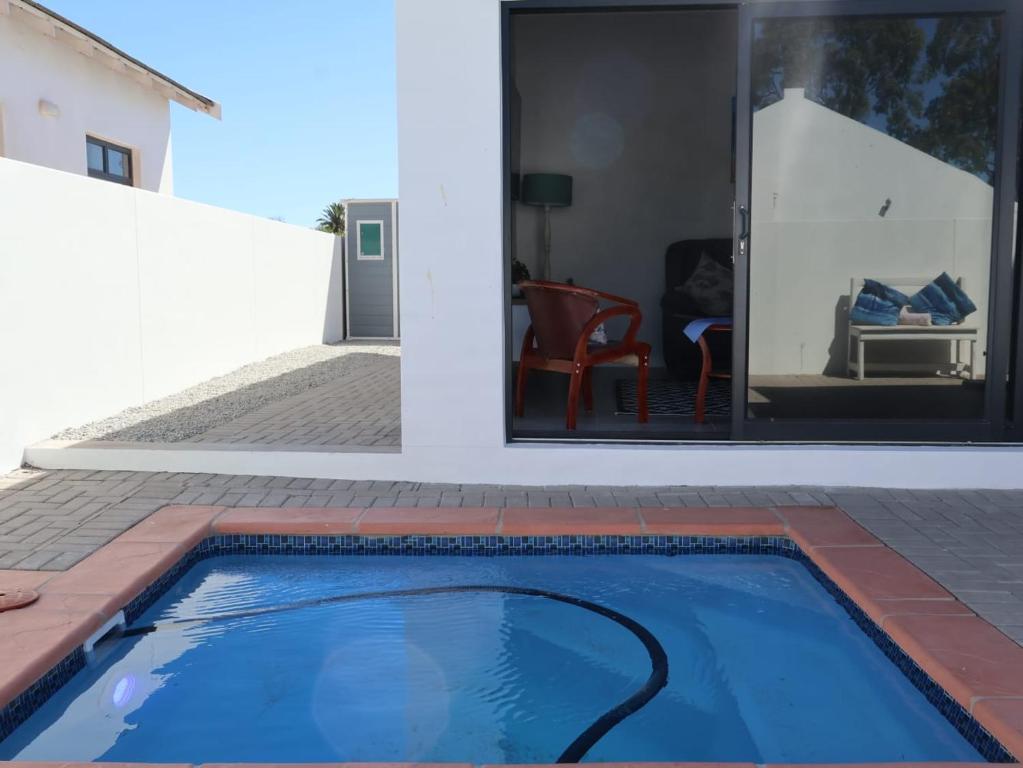 SerenShell House في Stompneusbaai: حمام سباحة أمام منزل
