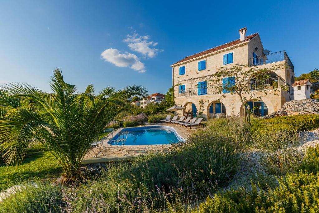 a house with a swimming pool in front of it at Villa Amarina in Trogir