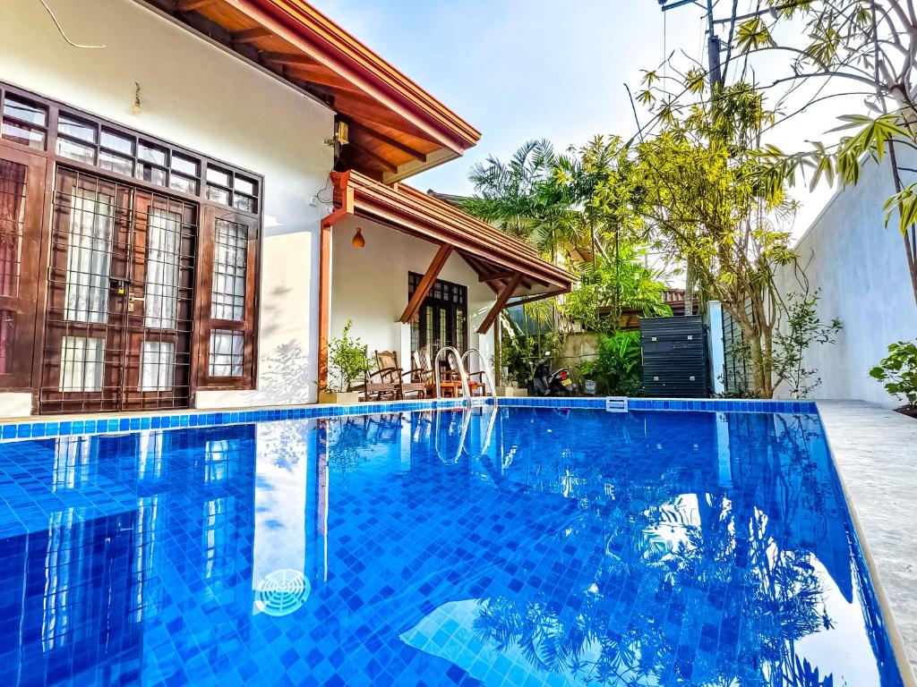 ein Bild eines Swimmingpools vor einem Haus in der Unterkunft City Beach Apartment in Bentota