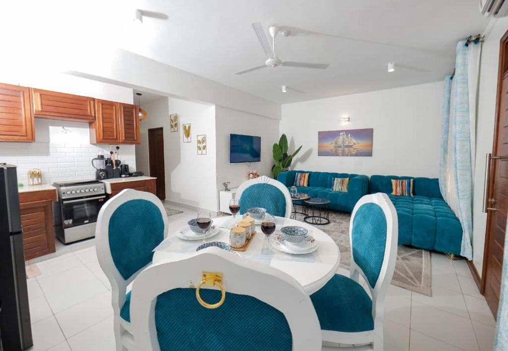 a kitchen and a living room with a table and chairs at 2 bedroom in watamu in Watamu