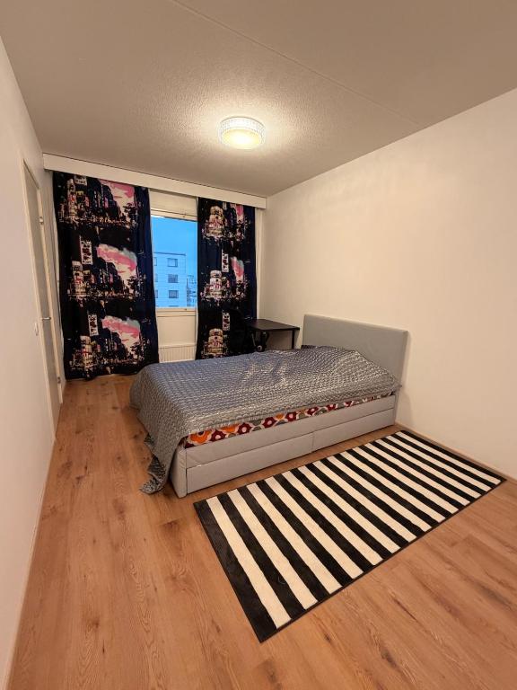 a bedroom with a bed and a rug at Helsinki Matinkylä Apartment in Espoo