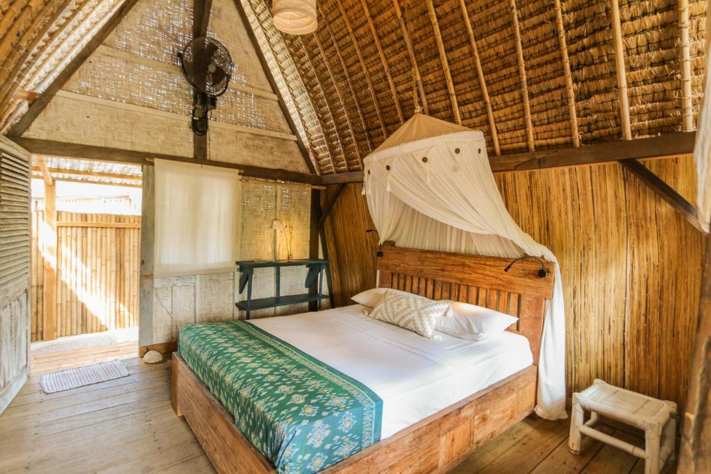 una camera con letto e zanzariera di MaoMeno Yoga Resort a Gili Meno