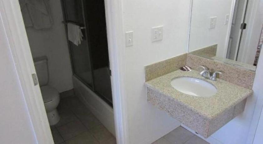 ein Badezimmer mit Waschbecken und Toilette in der Unterkunft Coast Motel in Signal Hill