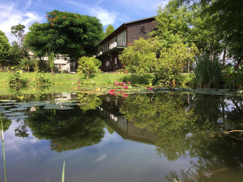 a house reflected in the water of a pond at Green Forest Villa in Yilan City