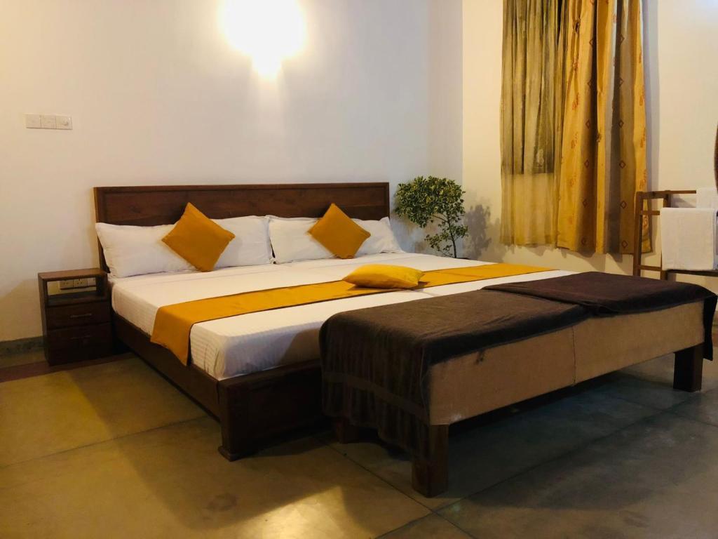 a bedroom with a large bed with yellow pillows at Borala Lake Weligama in Weligama