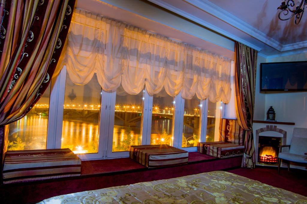 クラスノヤルスクにあるГостиница Огни Енисеяのベッドルーム(大きな窓、暖炉付)