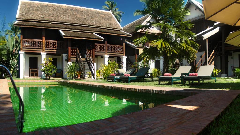 a house with a swimming pool in front of a house at Villa Maydou Boutique Hotel in Luang Prabang
