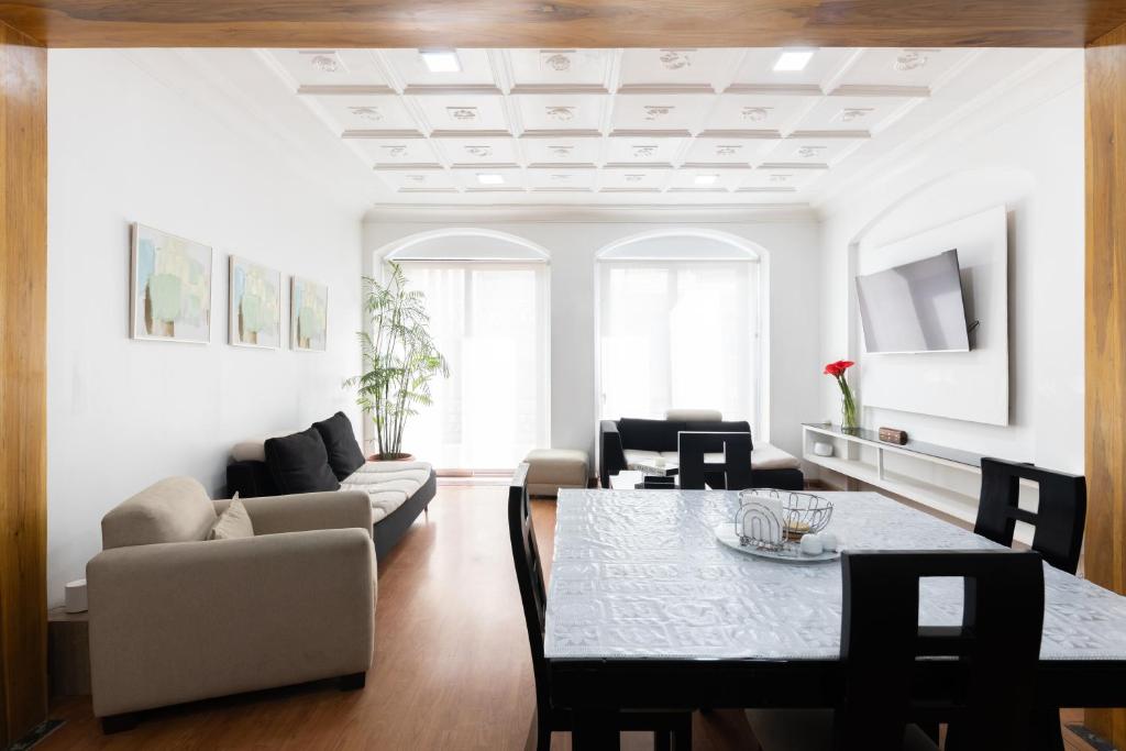 een woonkamer met een tafel en een bank bij Lumina Ste Presidencial in Cuenca