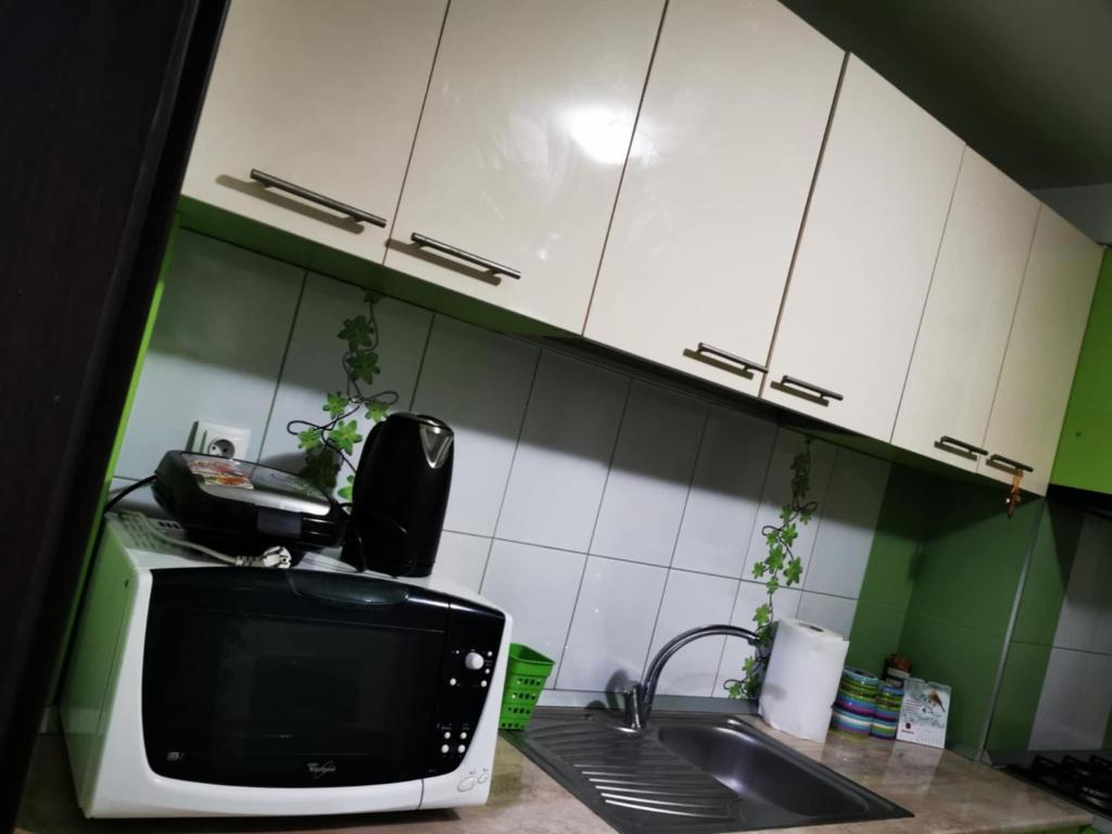 a kitchen with a sink and a microwave at Cc Apartament Central in Craiova