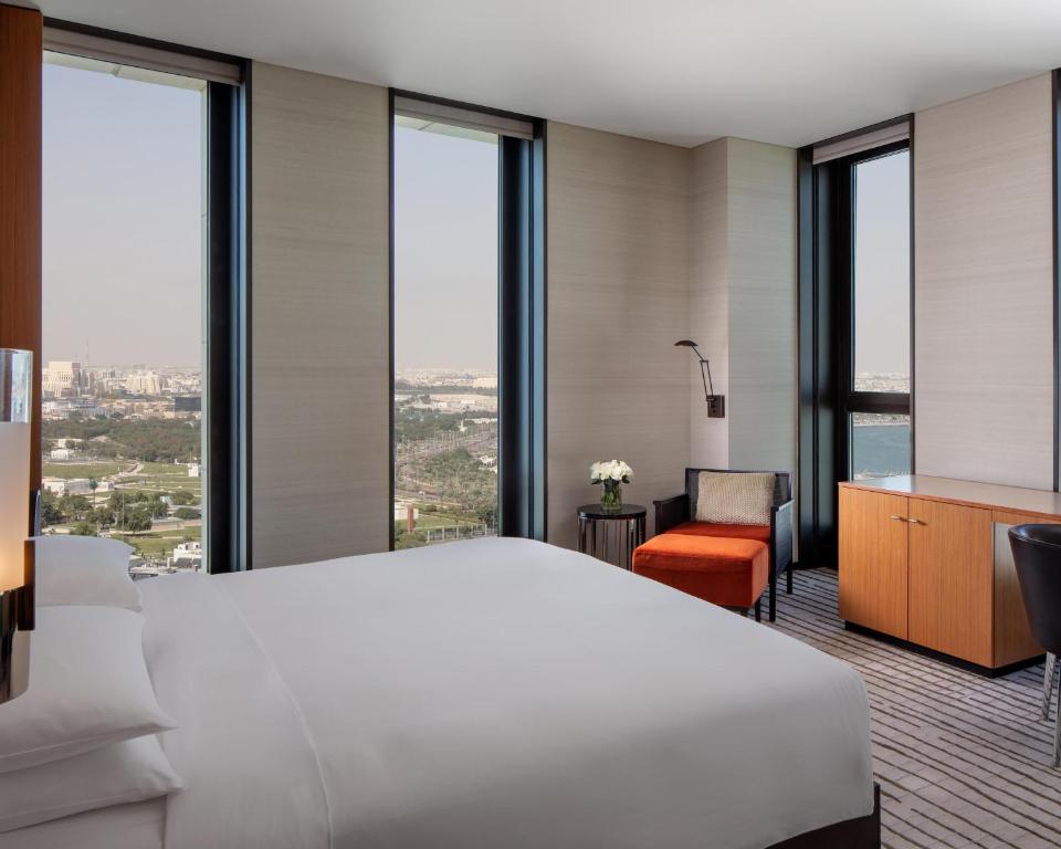 a bedroom with a large white bed and large windows at Park Hyatt Doha, Msheireb Downtown in Doha