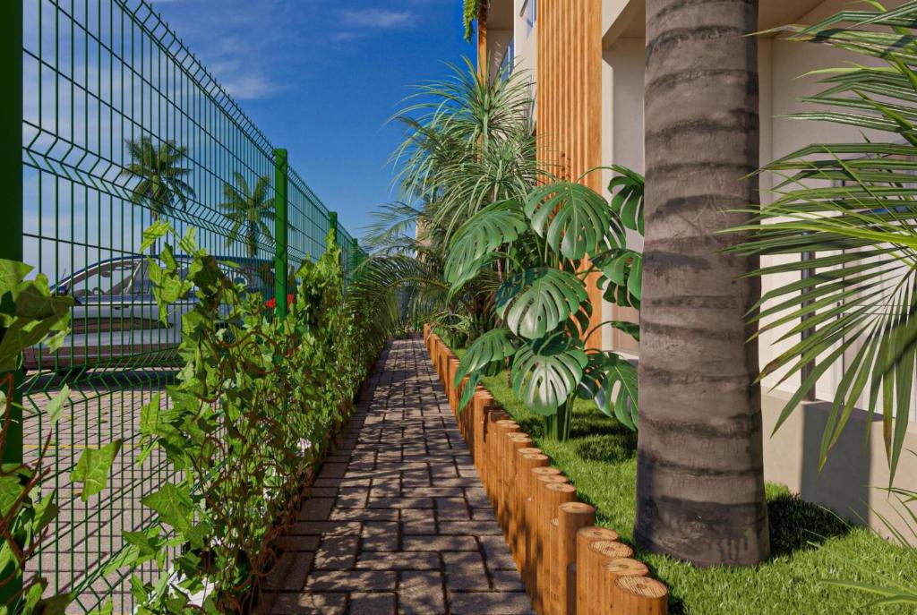 einen Garten mit einem Zaun und einer Palme in der Unterkunft Wyndham Natal Pitangui Praia in Extremóz