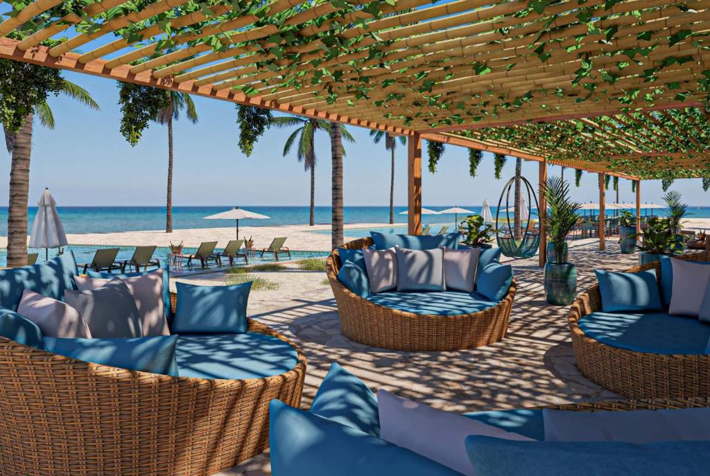 a patio with chairs and tables on the beach at Wyndham Natal Pitangui Praia in Extremóz