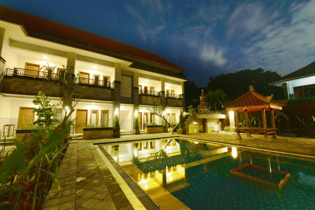 a villa with a swimming pool at night at Le Lima in Kuta