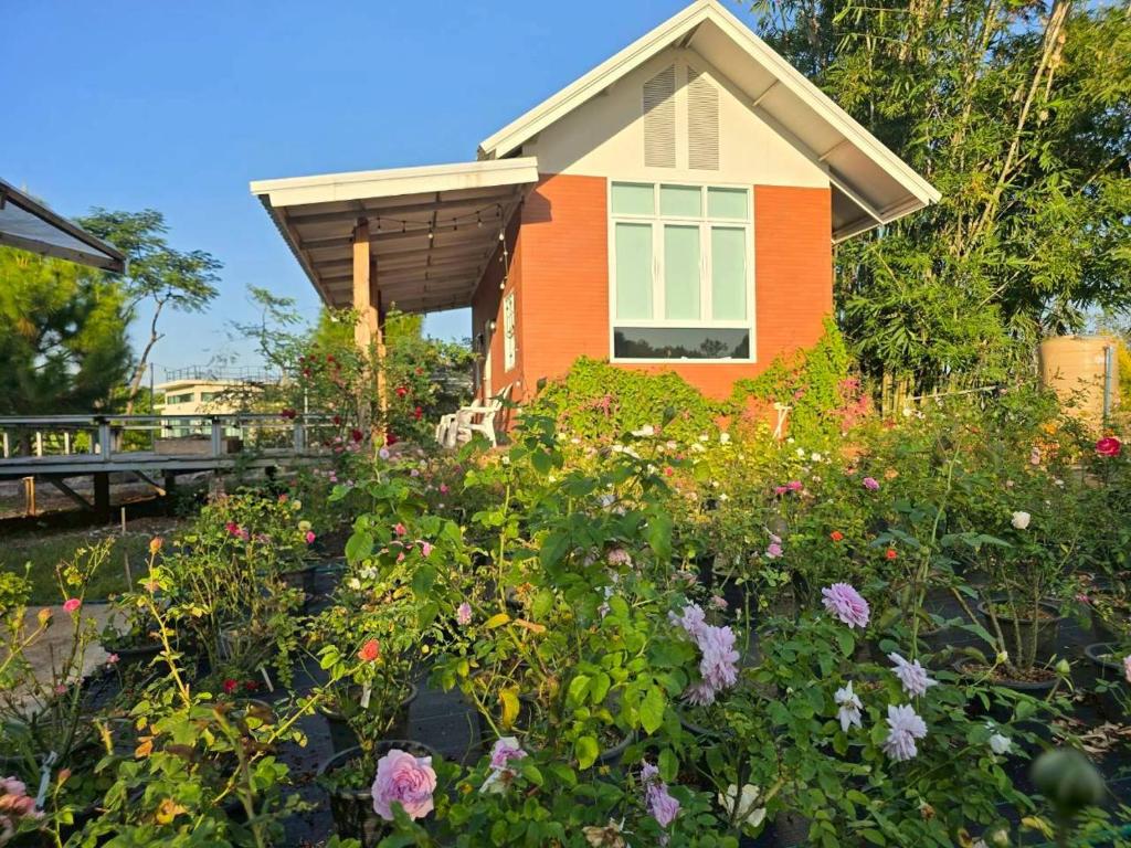 Ban Thamสะพรั่งกลางขุนเขา - Saprung on the mountain的房子前面的花园，种满鲜花