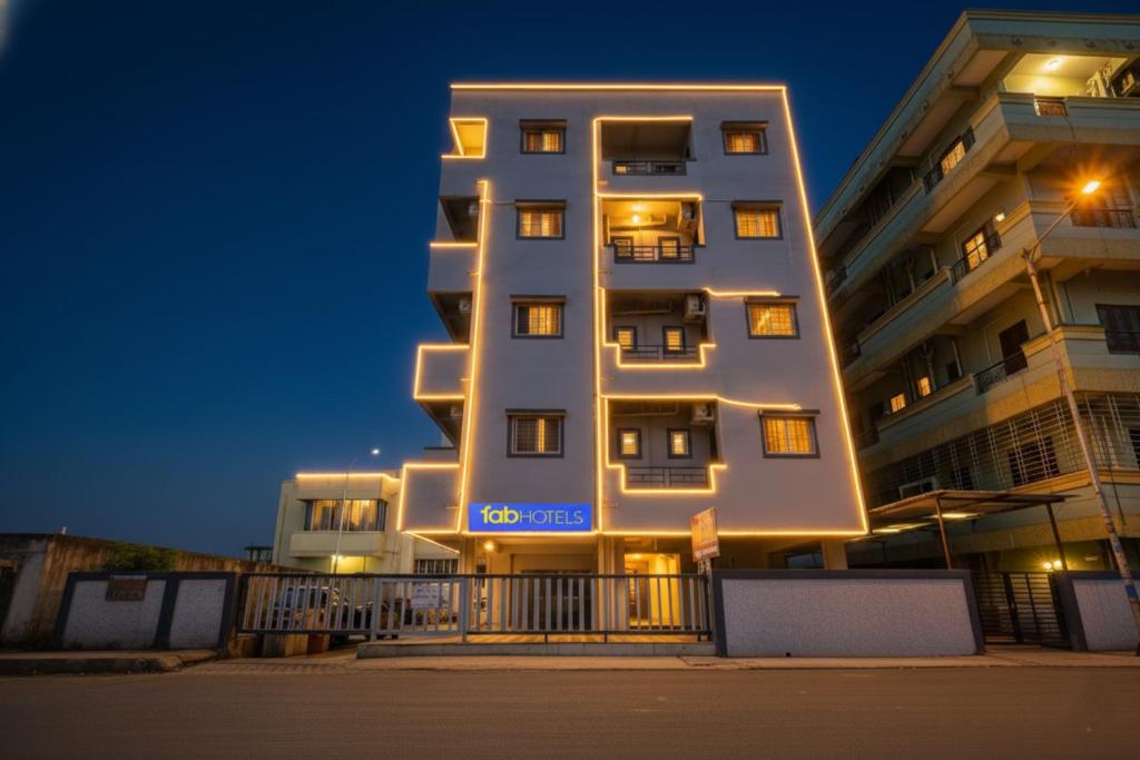 a tall white building with lights on it at night at Via Diamond Inn in Pune