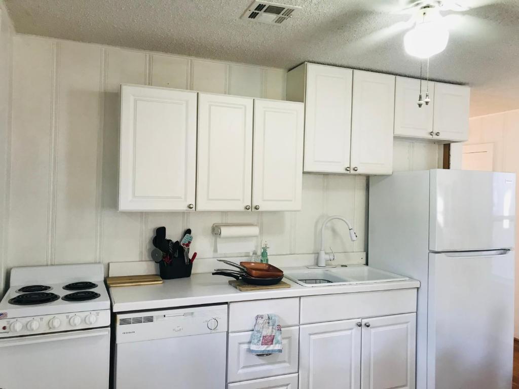 a kitchen with white cabinets and a white refrigerator at Garden Cottage in Langley