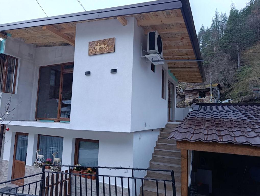 a house with a staircase and a tv on the side at Къща за гости НА СЕЛО in Devin
