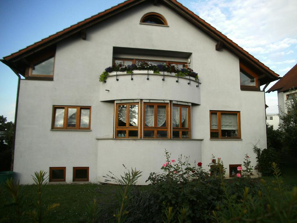 Briem Wohngefühl Vermietung في فيلدرشتادت: منزل أبيض مع نافذة عليها زهور