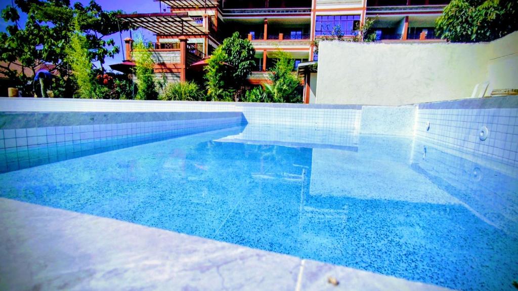 una piscina di fronte a un edificio di Kusi Hotel Kakamega a Kakamega