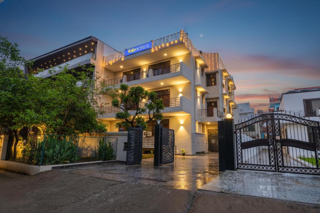 ein weißes Gebäude mit einem Tor davor in der Unterkunft FabHotel Next Home Prime in Gurgaon