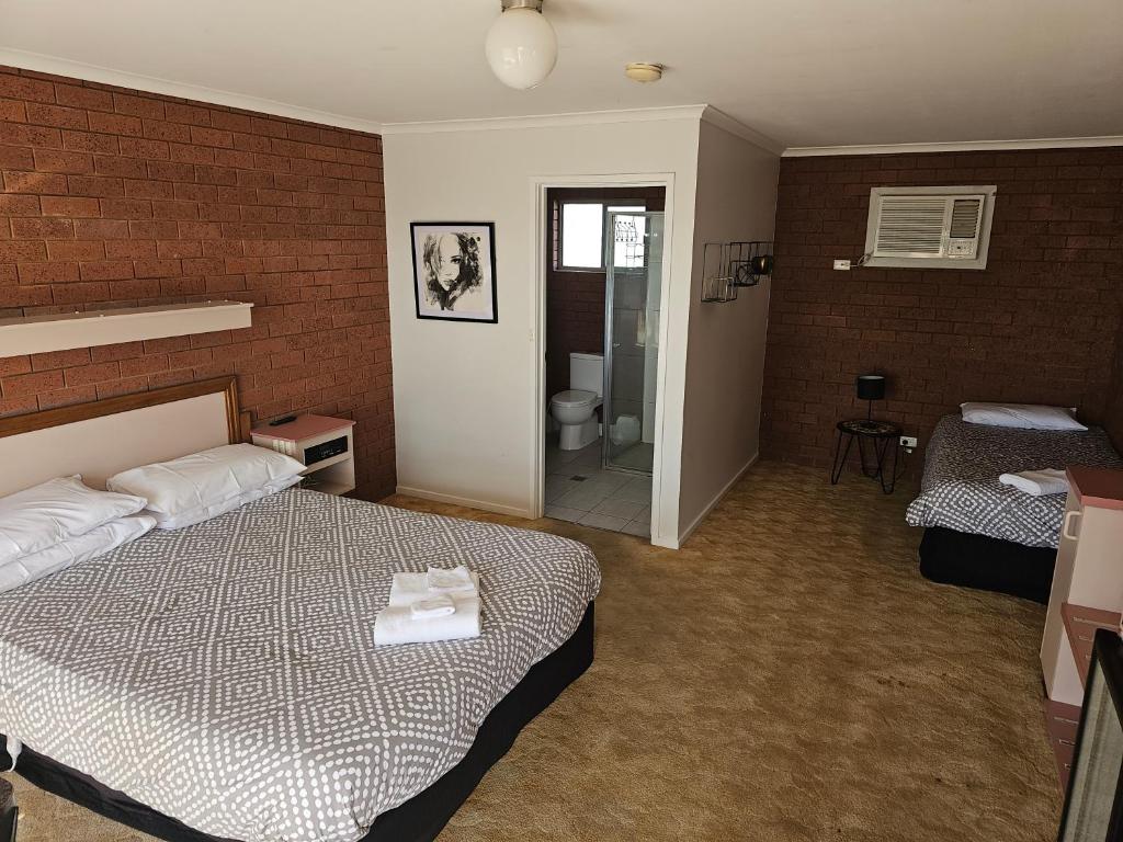 a hotel room with a bed and a bathroom at Star Hotel Rutherglen in Rutherglen