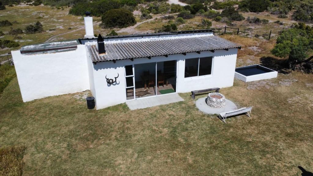 una vista dall'alto di una piccola casa bianca con un patio di Die Jaghuisie at Blombosch Game Farm a Yzerfontein