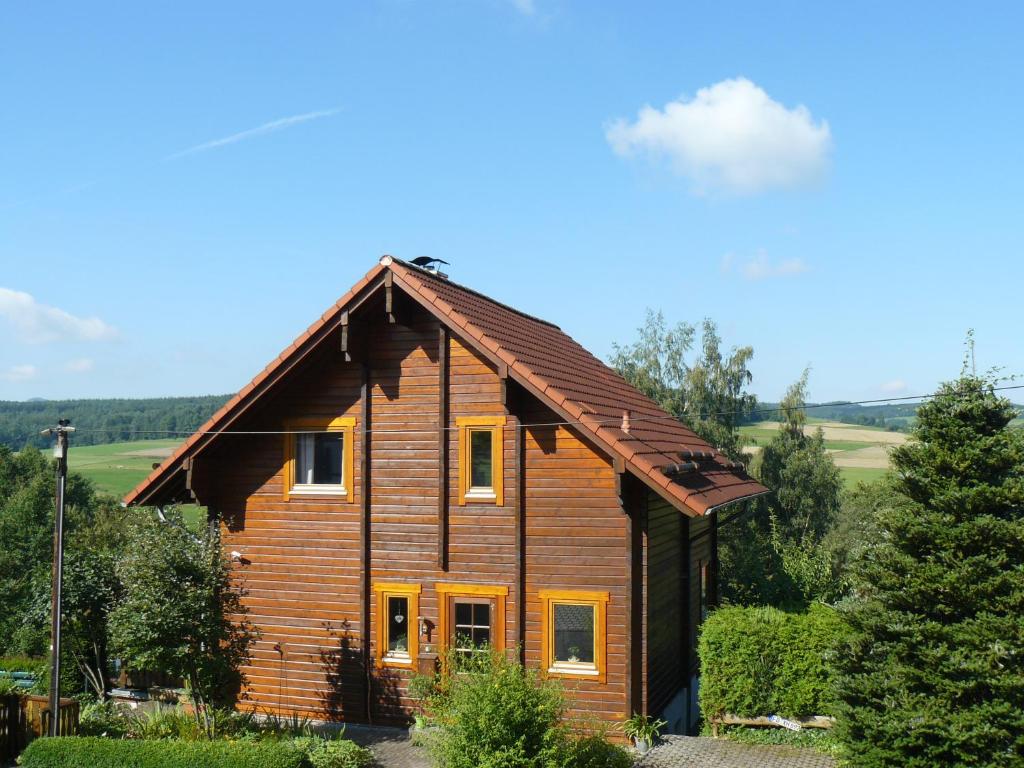 a wooden house with a wooden roof at Ferienhaus Berg.erleben in Hilders