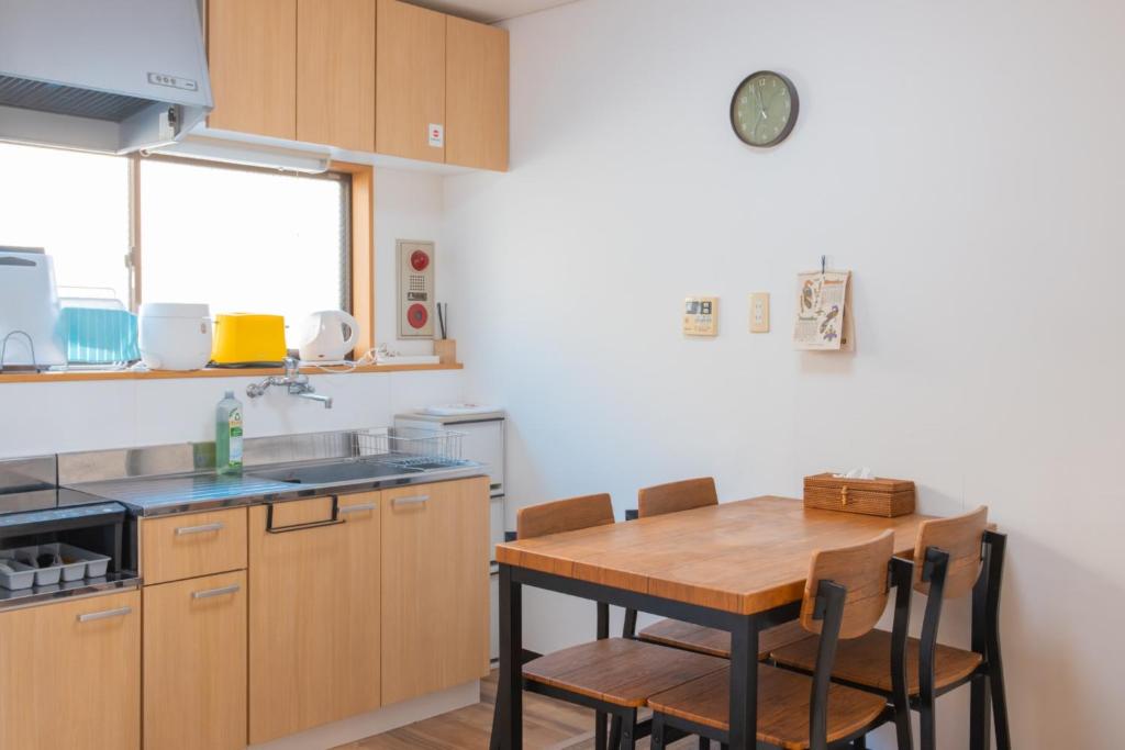 una cocina con mesa de madera y sillas. en Guesthouse & Kitchen Hace - Vacation STAY 68911v, en Iwaki