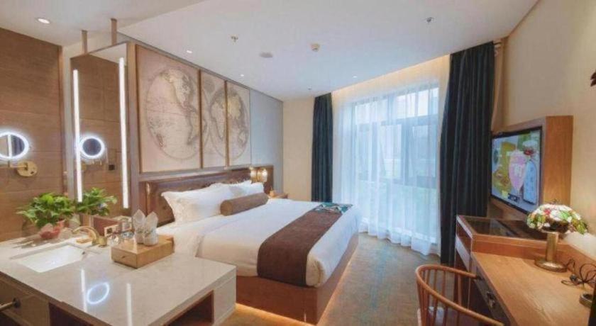 um quarto de hotel com uma cama e uma escrivaninha em James Joyce Coffetel Changsha Wanjiali Baoqiaobei Metro Station em Changsha