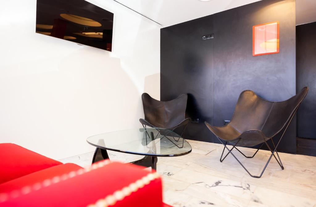 a living room with two chairs and a glass table at Faro Boutique Hotel in Faro