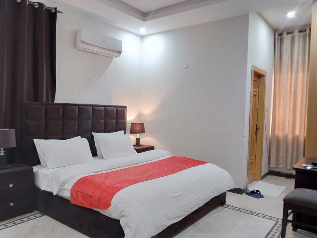 a bedroom with a large bed with a red blanket at Islamabad Pak Palace guest house in Islamabad