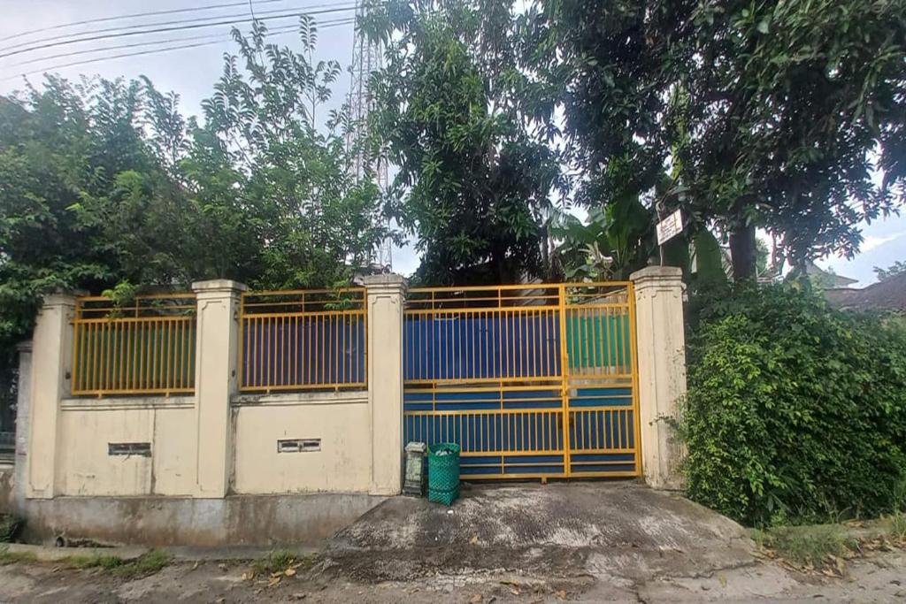a gate with a yellow and blue fence at OYO 95054 Prima Jaya Homestay Syariah in Kedungtengkong